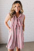 BLONDE WOMAN WEARING VERTICAL STRIPED TRIPLE FRONT BOW DETAIL MINI DRESS.