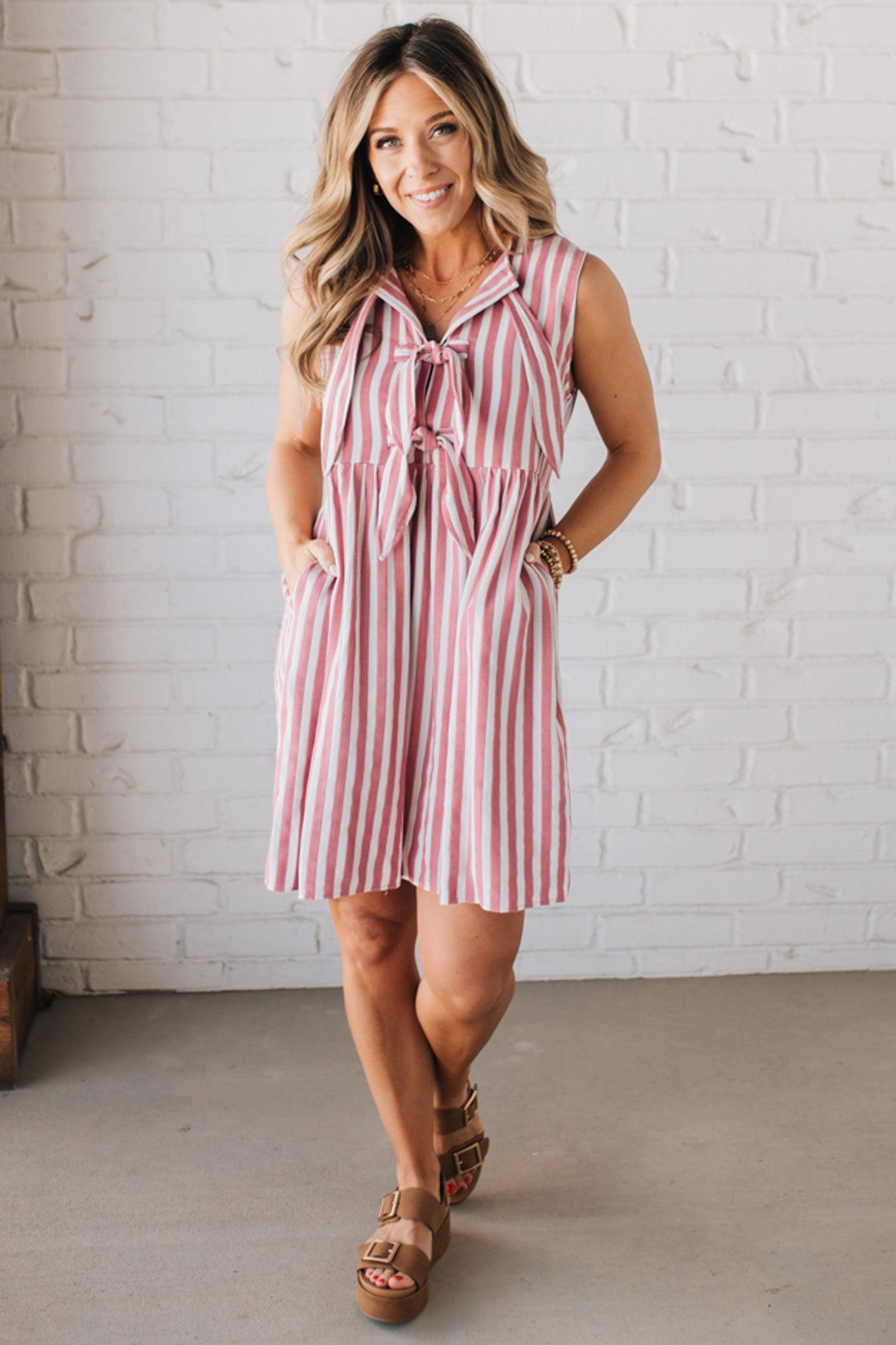 BLONDE WOMAN WEARING VERTICAL STRIPED TRIPLE FRONT BOW DETAIL MINI DRESS.