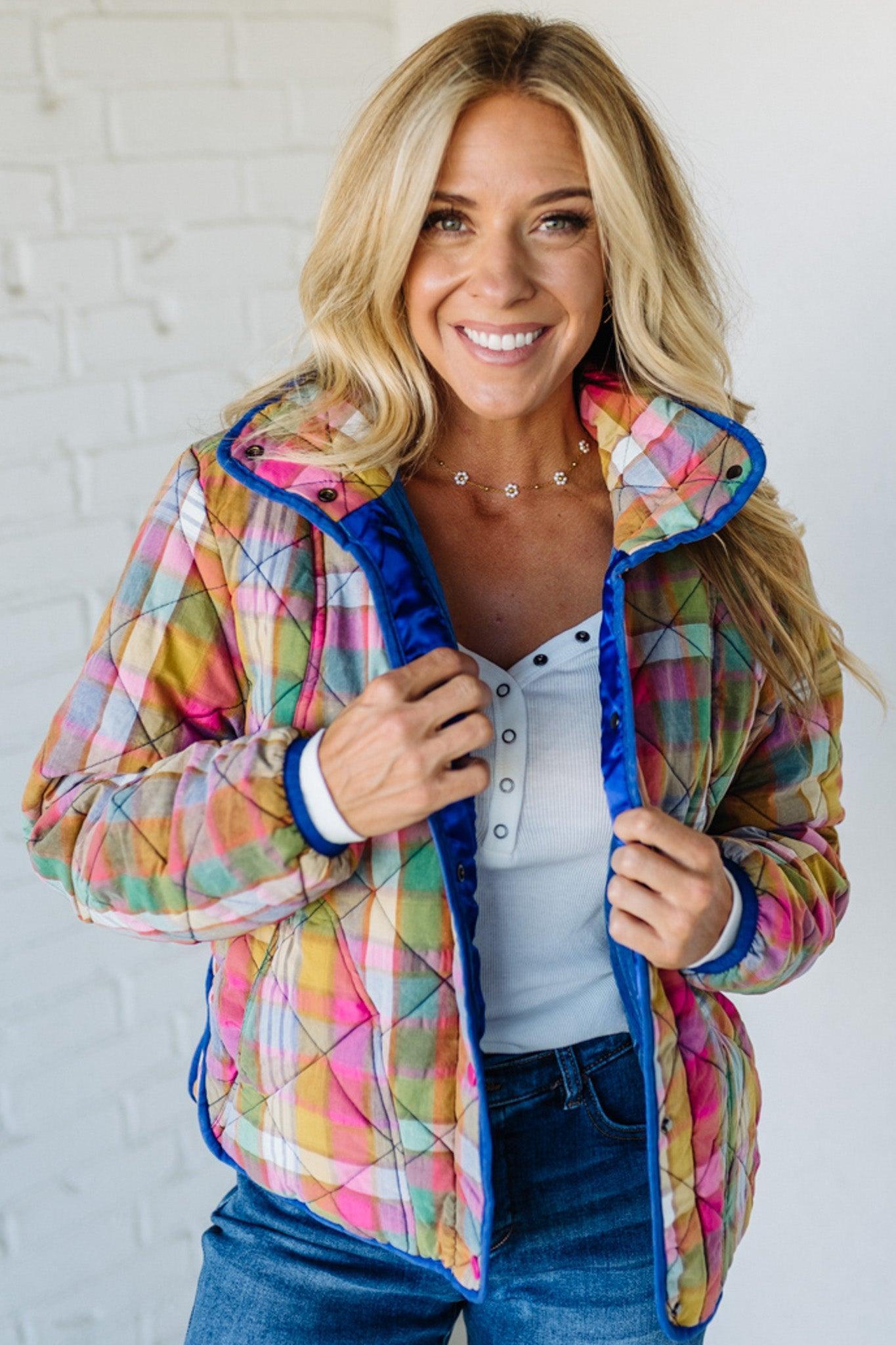 Woman wearing a colorful quilted jacket against a white background