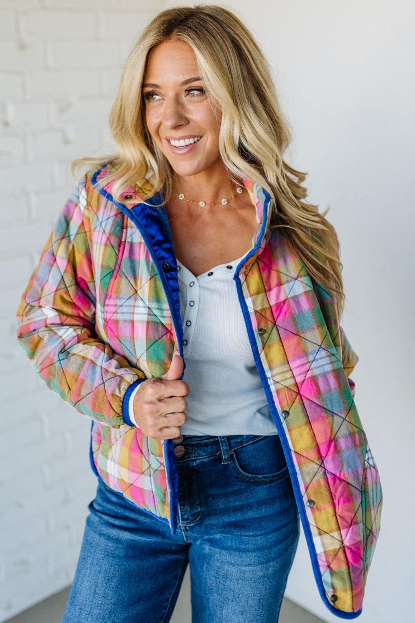Woman wearing a colorful quilted jacket with a white background