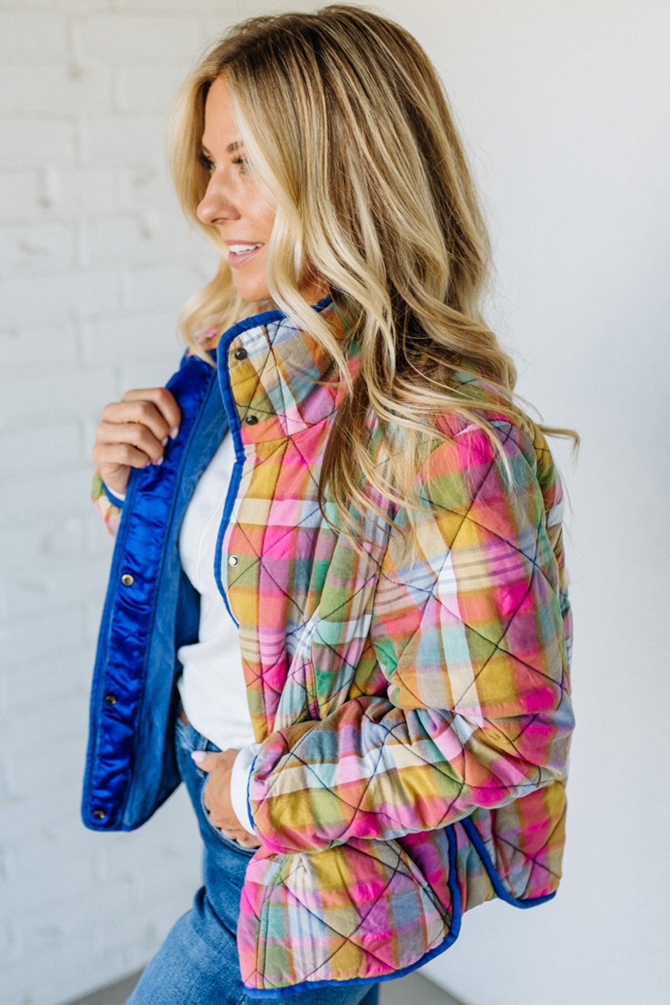 Woman wearing a colorful quilted jacket with a white background