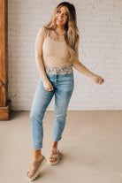 Blonde woman in blue jeans wearing a long sleeve mesh lace top with merrow hem.