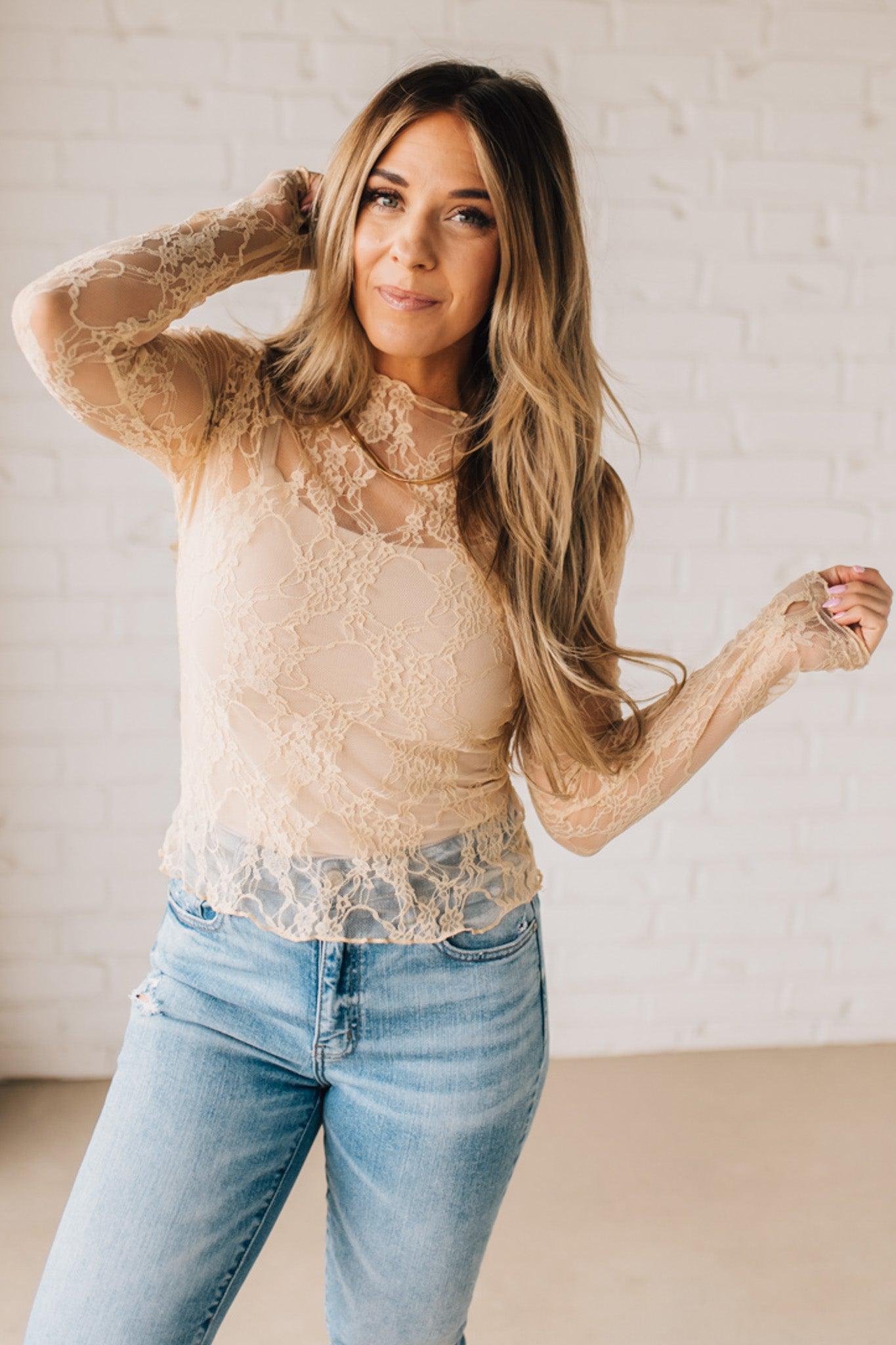 Blonde woman in blue jeans wearing a long sleeve mesh lace top with merrow hem.