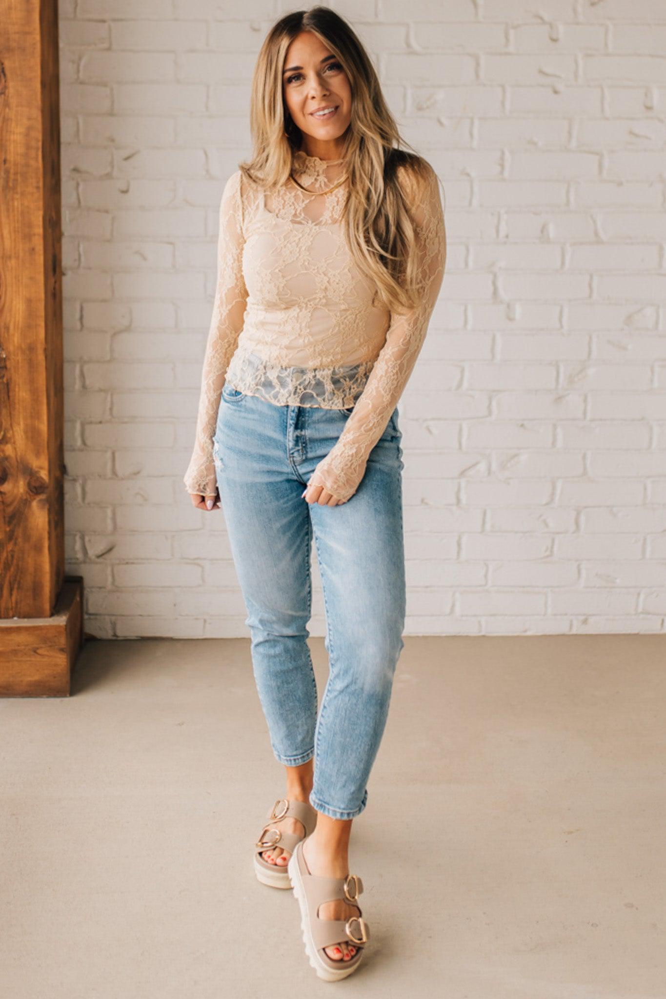 Blonde woman in blue jeans wearing a long sleeve mesh lace top with merrow hem.