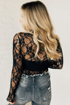 Blonde woman in blue jeans wearing a long sleeve mesh lace top with merrow hem.