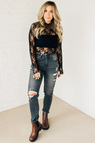 Blonde woman in blue jeans wearing a long sleeve mesh lace top with merrow hem.