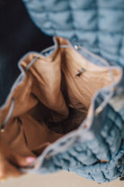 Blonde woman wearing a Blue Quilted Puffer Design Backpack with Easy Wipe Nylon Exterior.