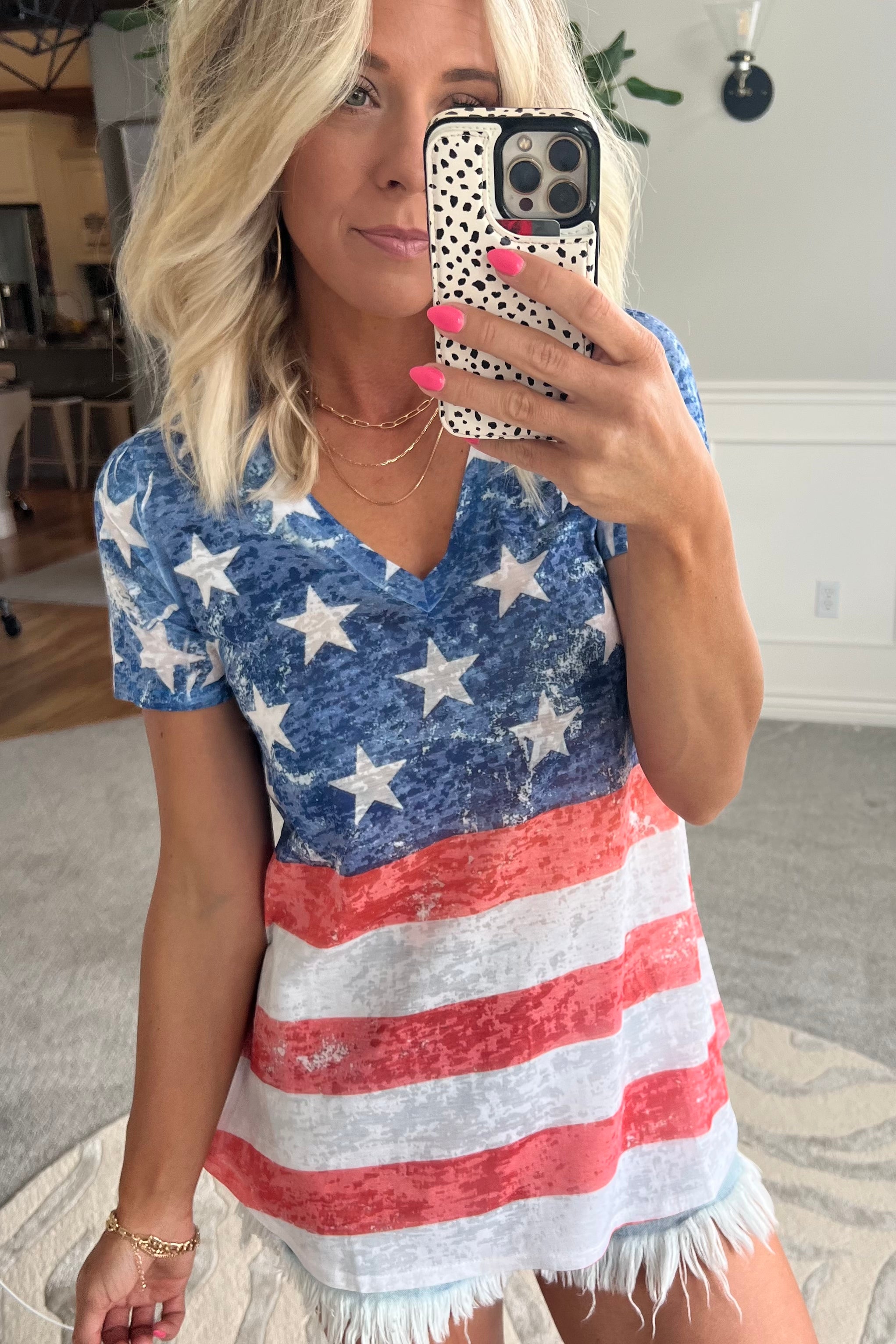 women wearing a red, white and blue American Flag V Neck tee and cut off denim shorts