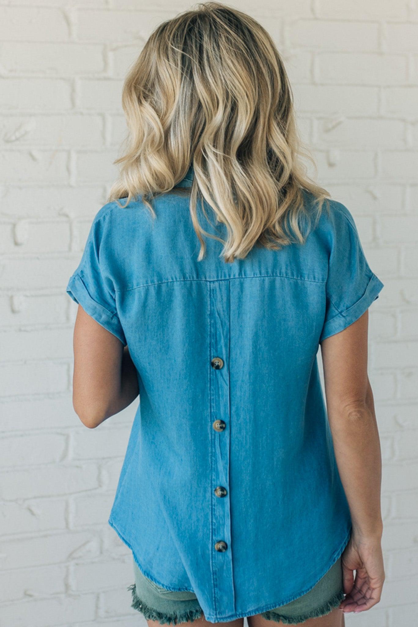 Women wearing a lightweight chambray top with short, cuffed sleeves and buttons down the back.