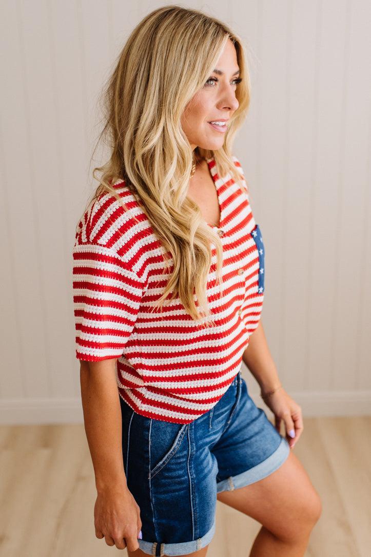 Woman wearing a red and white striped shirt with denim shorts indoors.