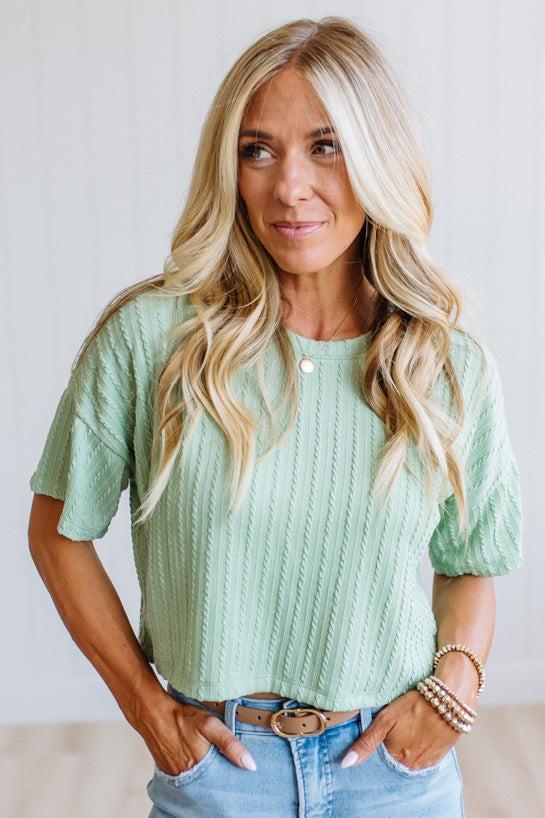Blonde woman wearing a Lightweight Cable Knit T Shirt with Textured Vertical Cable-Inspired Knit and a Boxy Loose Silhouette with Drop-Shoulder detail.