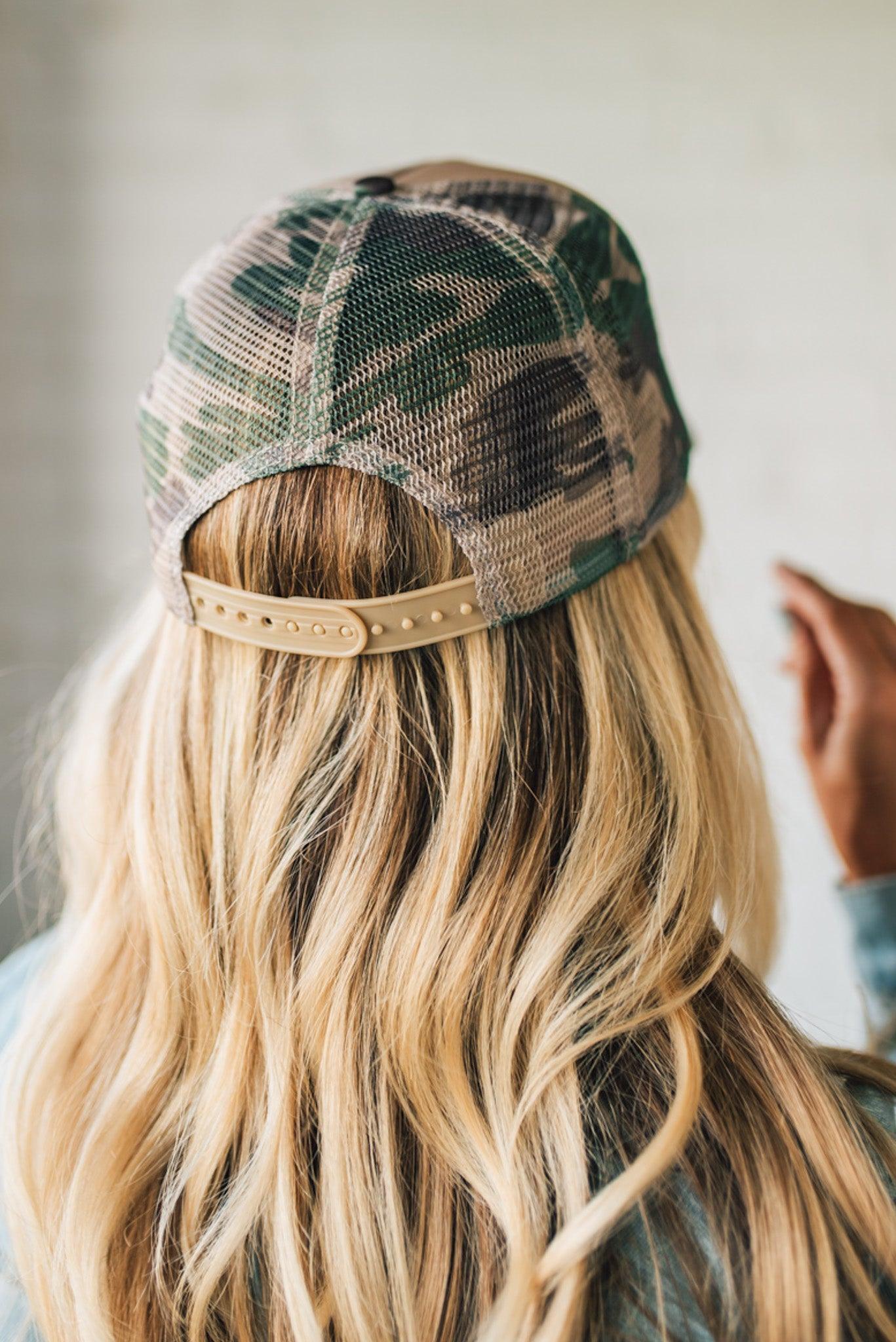 Person wearing a camo patterned cap with a neutral color scheme.