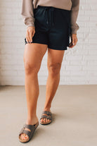 BLONDE WOMAN WEARING SCUBA THIGH POCKET SHORTS WITH ELASTIC WAIST & DRAWSTRING. 