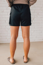 BLONDE WOMAN WEARING SCUBA THIGH POCKET SHORTS WITH ELASTIC WAIST & DRAWSTRING. 