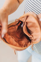 Woman wearing a camel colored nylon monochromatic crossbody bag.