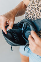 Blonde woman in a leopard tee shirt wearing a black Essential Nylon Crossbody bag.