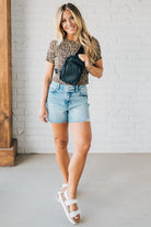 Blonde woman in a leopard tee shirt wearing a black Essential Nylon Crossbody bag.