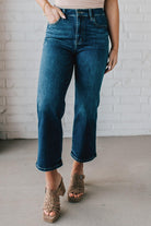 5'4" tall girl modeling a pair of cropped denim in a dark wash with no distressing