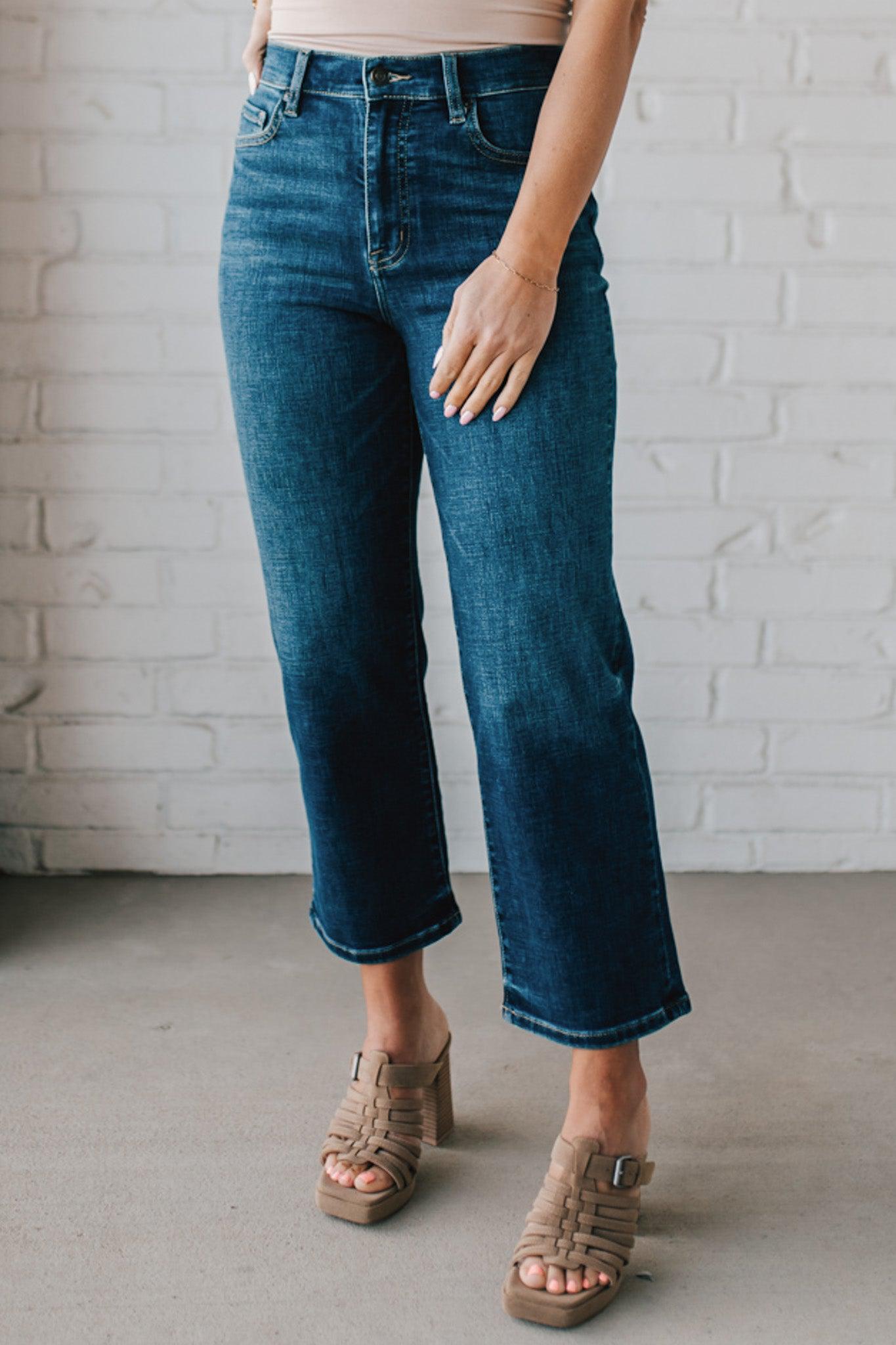 5'4" tall girl modeling a pair of cropped denim in a dark wash with no distressing