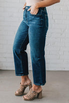 5'4" tall girl modeling a pair of cropped denim in a dark wash with no distressing