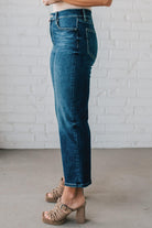 5'4" tall girl modeling a pair of cropped denim in a dark wash with no distressing