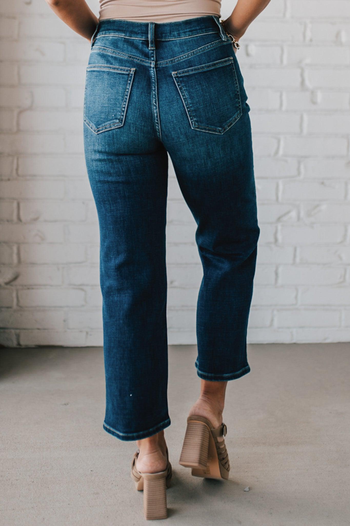 5'4" tall girl modeling a pair of cropped denim in a dark wash with no distressing