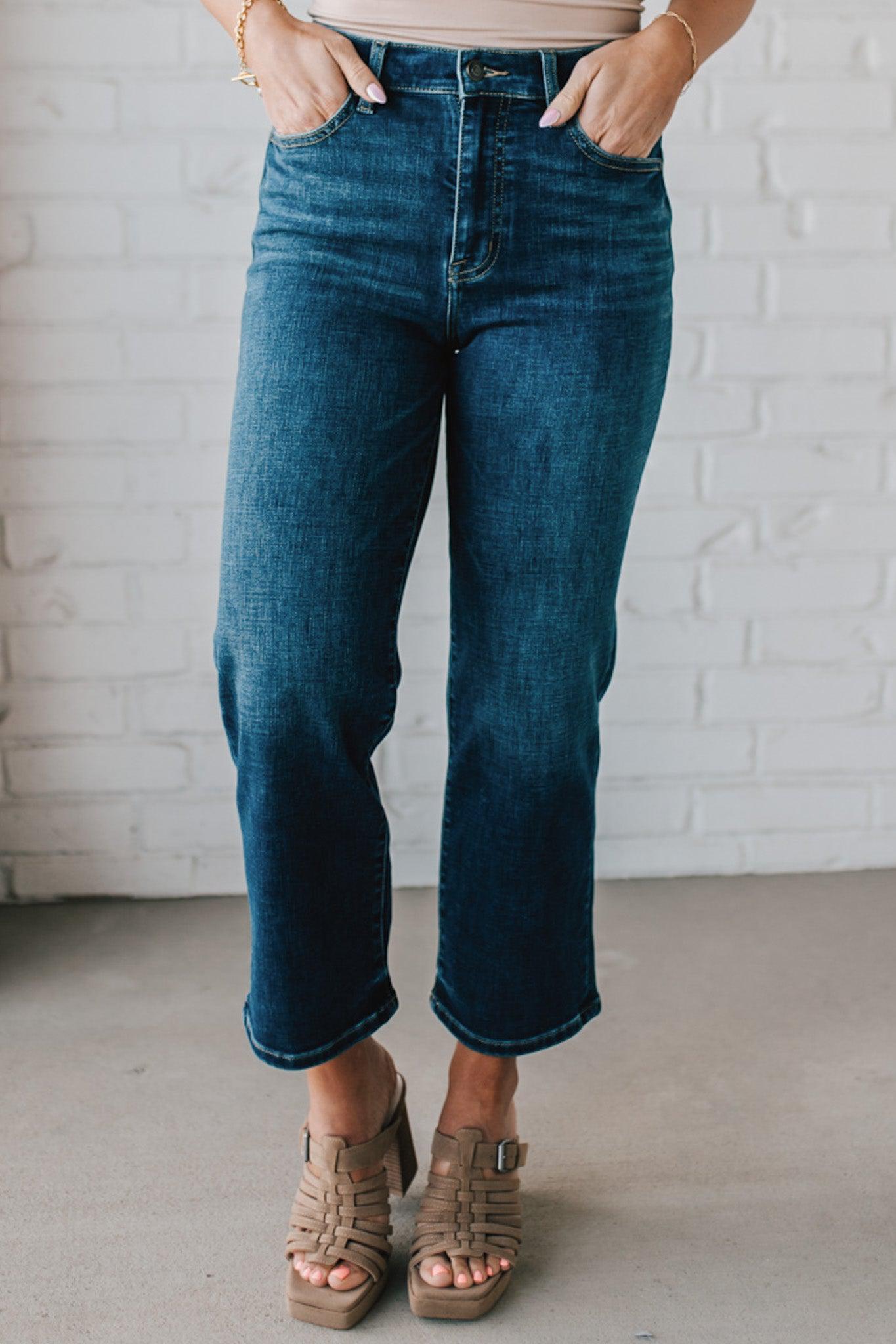 5'4" tall girl modeling a pair of cropped denim in a dark wash with no distressing