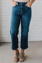 5'4" tall girl modeling a pair of cropped denim in a dark wash with no distressing