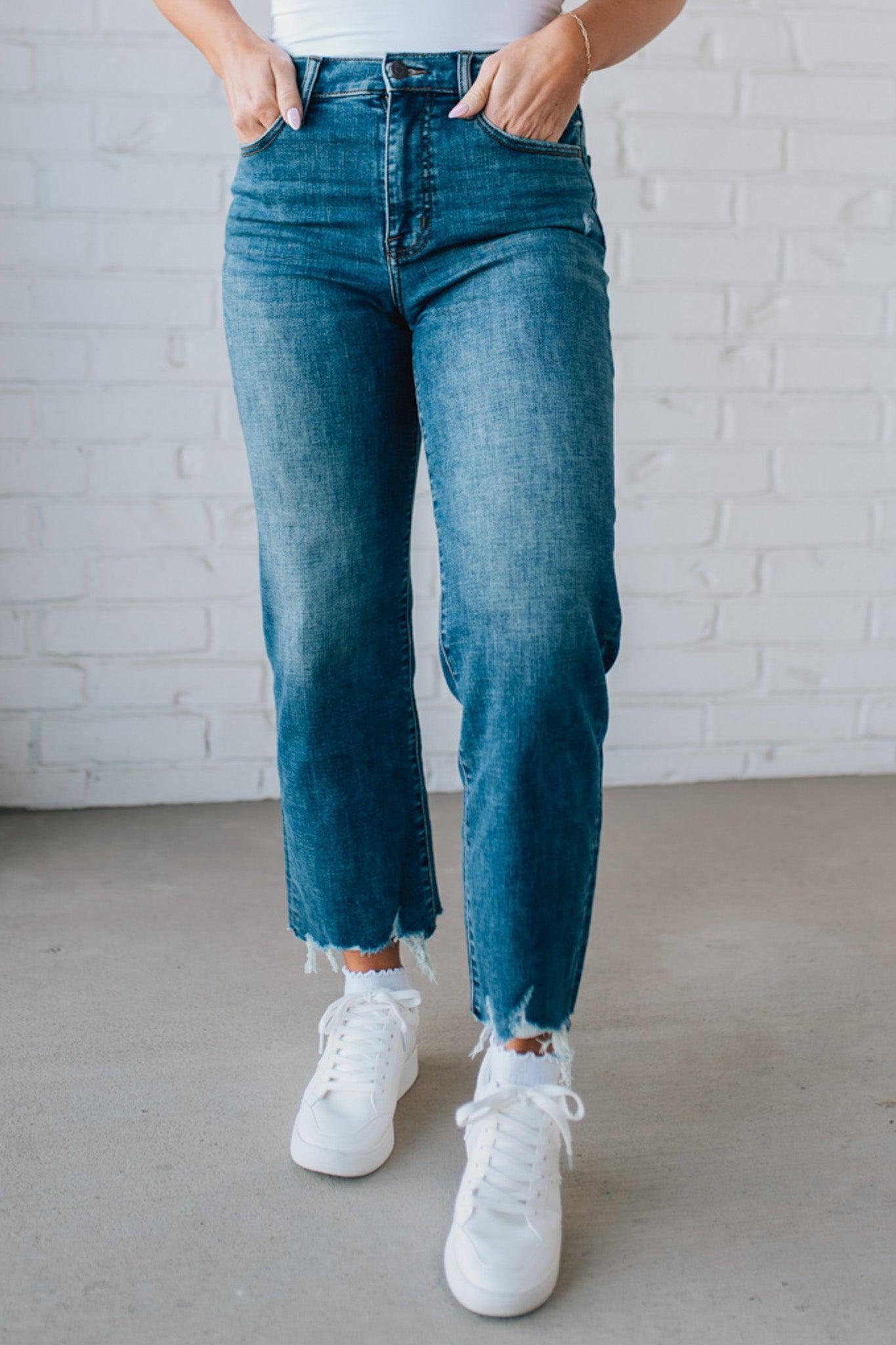 5'4" tall girl modeling a crop denim pant in a medium wash with a frayed hem and no distressing