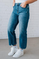 5'4" tall girl modeling a crop denim pant in a medium wash with a frayed hem and no distressing