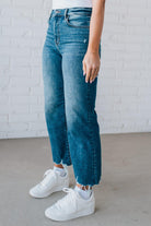 5'4" tall girl modeling a crop denim pant in a medium wash with a frayed hem and no distressing