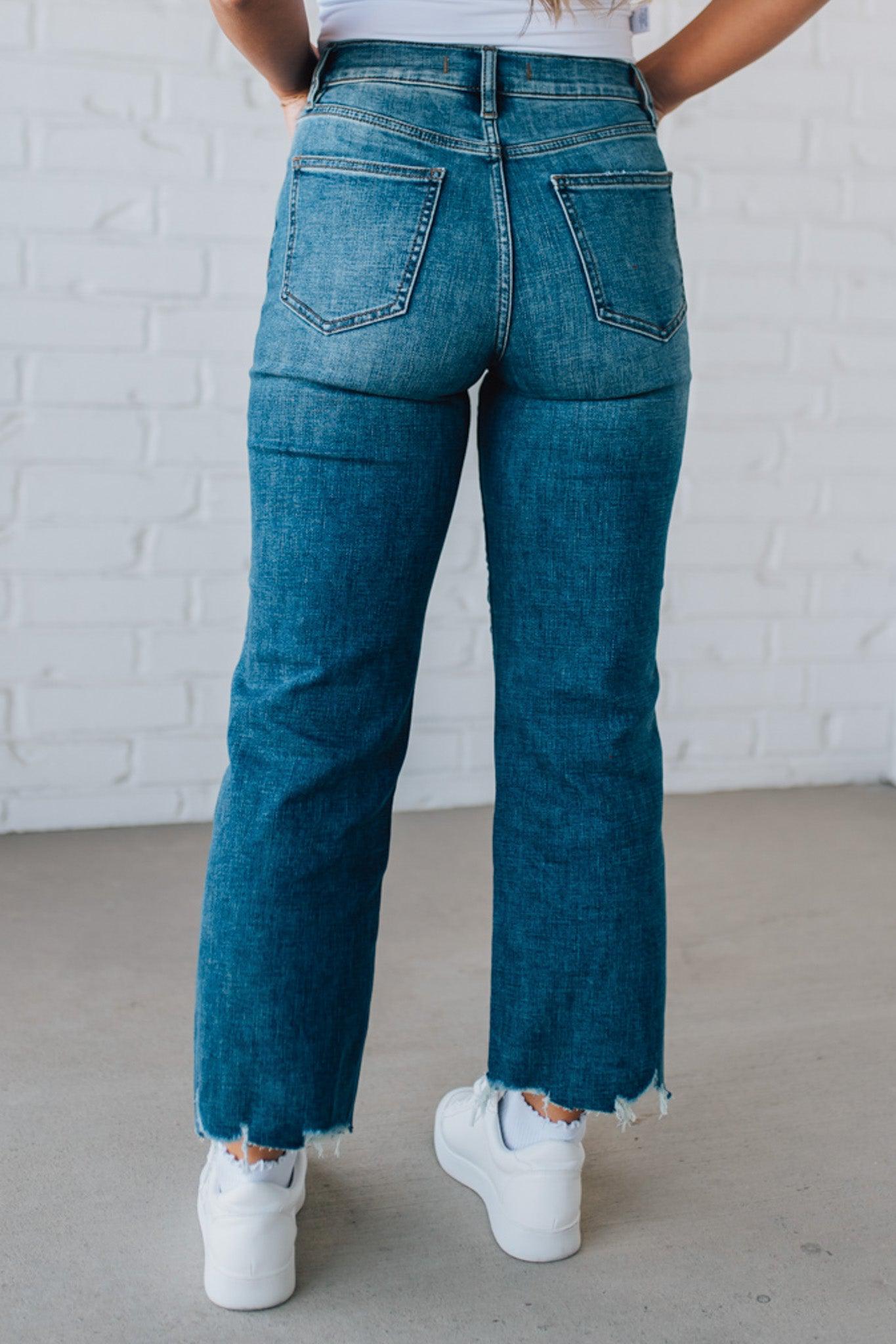 5'4" tall girl modeling a crop denim pant in a medium wash with a frayed hem and no distressing