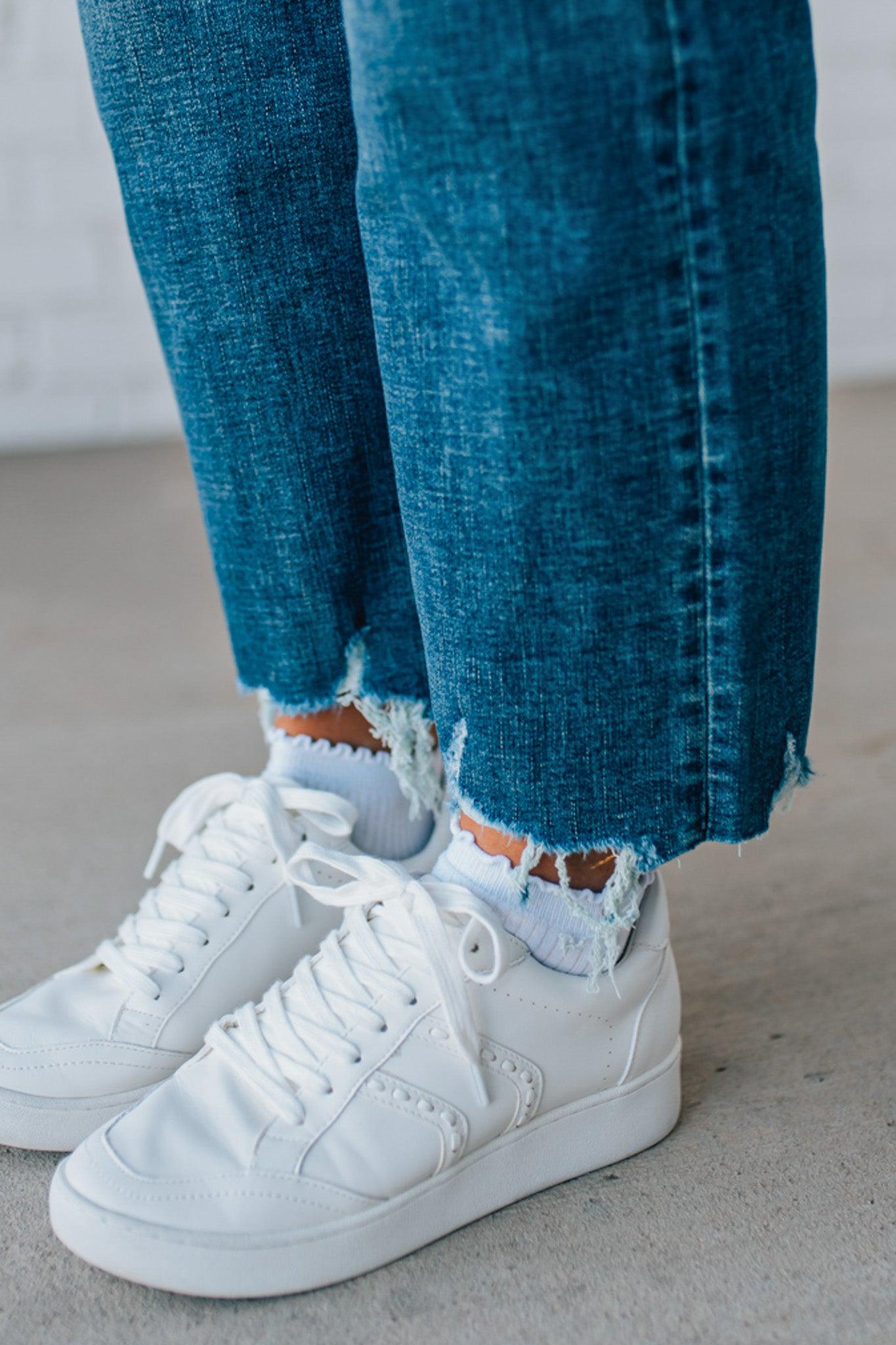 5'4" tall girl modeling a crop denim pant in a medium wash with a frayed hem and no distressing