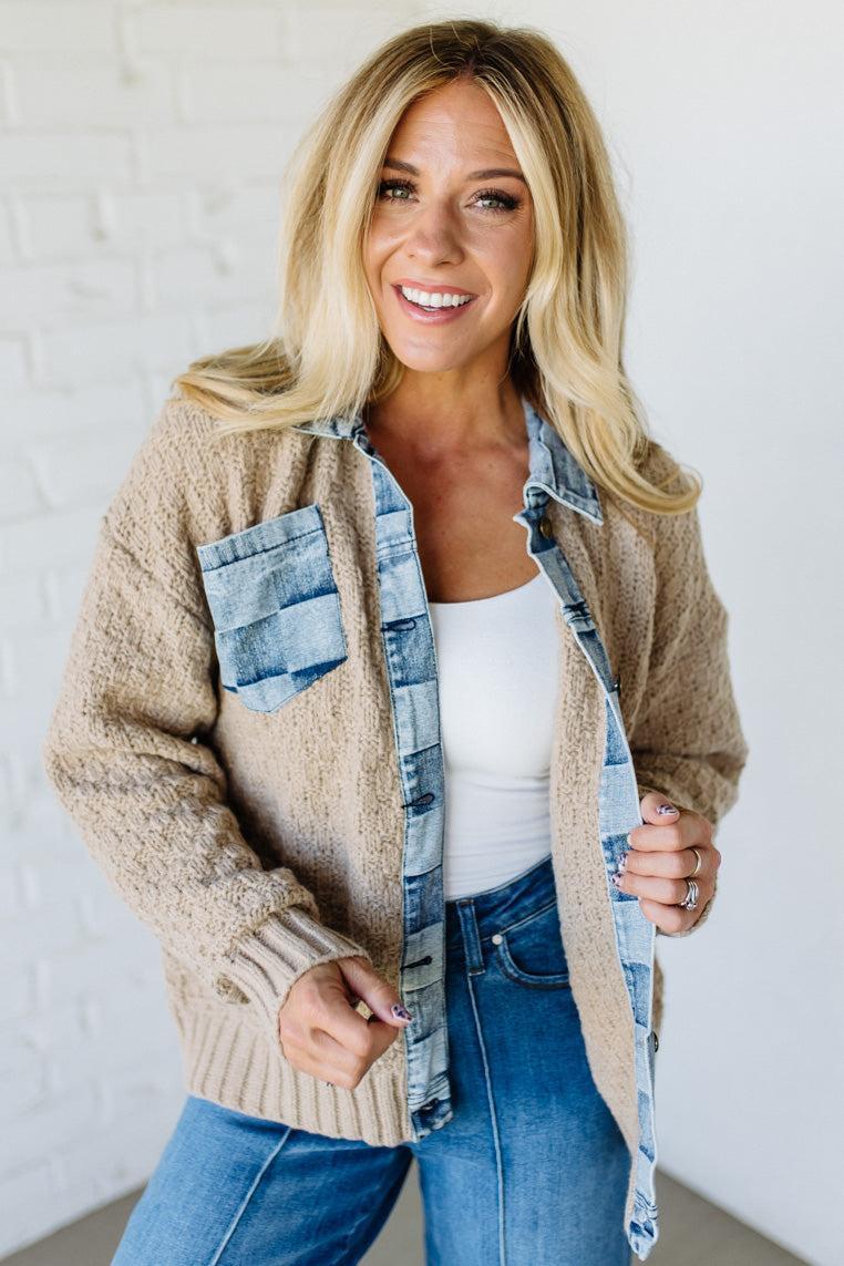 Woman wearing a beige cardigan with a denim trim with a white background