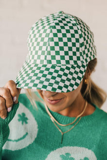  Blonde woman wearing a green and white checkered ball cap. 