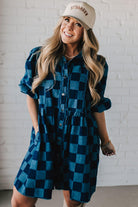 Blonde woman wearing a hat and boots with checkered denim knee length dress.