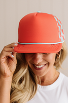 Person wearing a red cap with white accents, smiling.