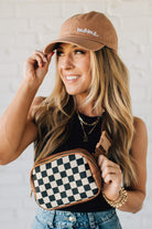 Blonde Woman in a Hat with a Mixed Texture Check Sling Belt Bum Bag across her body.