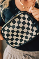 Person holding a black and white checkered bag