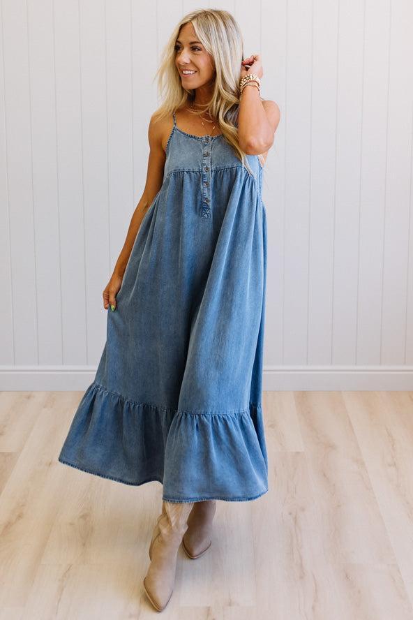 Woman wearing a blue denim dress with a white background