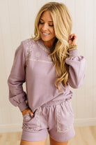 Woman wearing a lavender loungewear set with embroidery details.