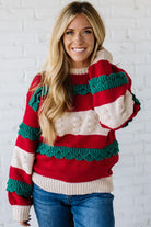 BLONDE WOMAN WEARING A CHRISTMAS THEME RUFFLED DETAILS SWEATER TOP IN RED, CREAM, AND HUNTER GREEN.