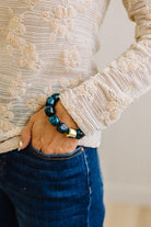 Dark Cyan bead bracelet with a gold accent bead shown on a woman's wrist in her pocket.
