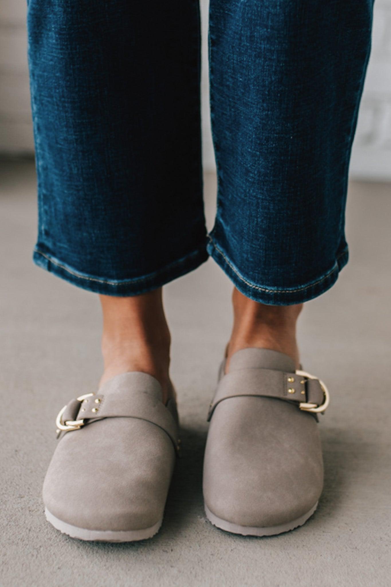 girl modeling a warm grey colored suede clog with a gold buckle