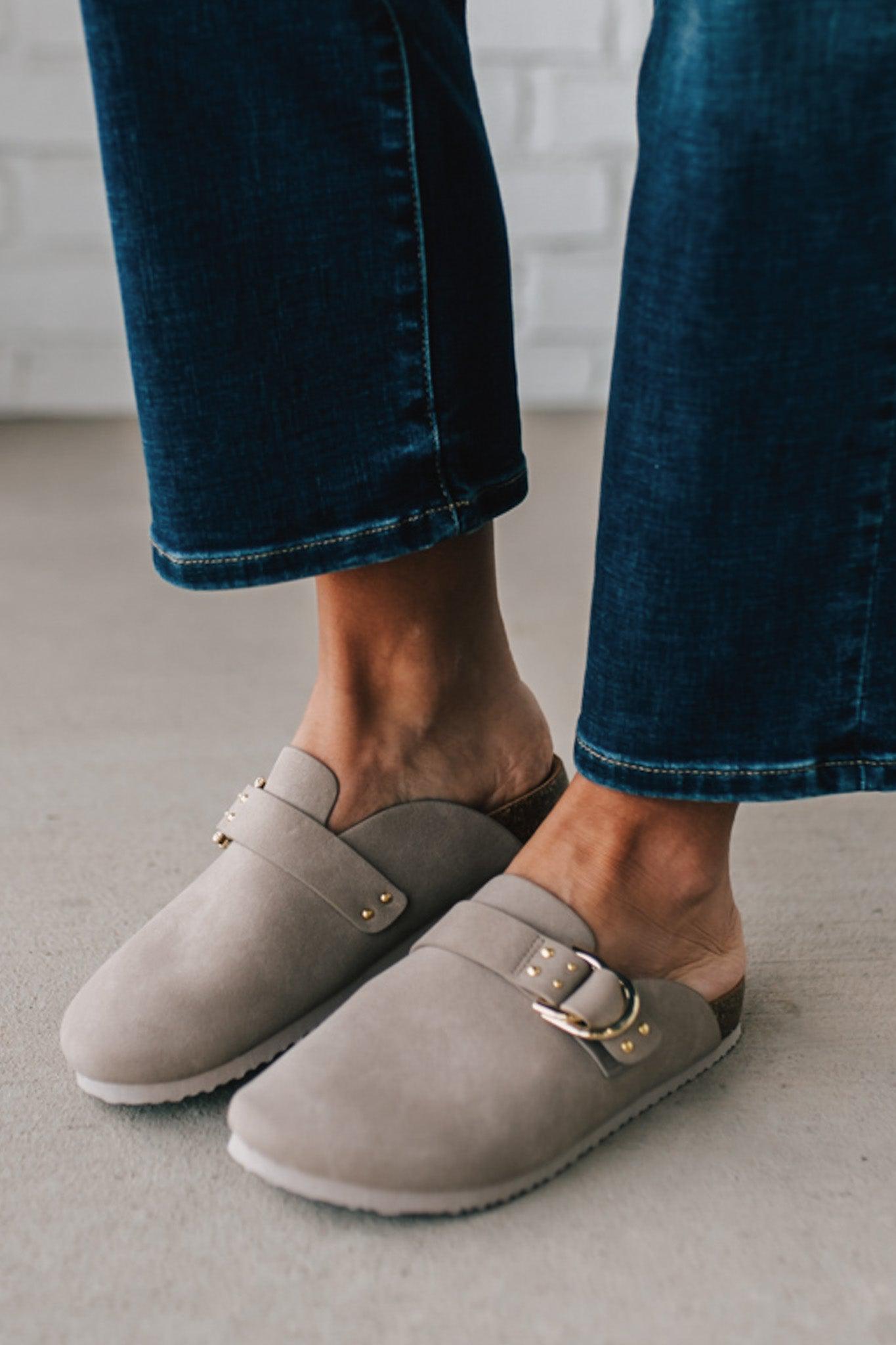 girl modeling a warm grey colored suede clog with a gold buckle