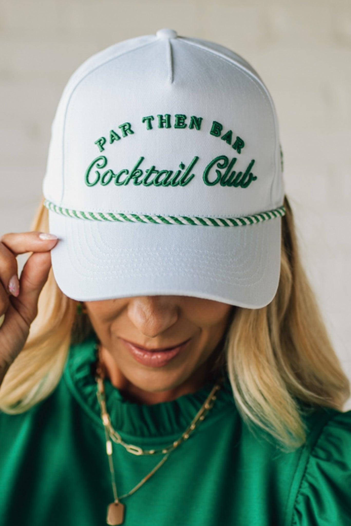 Blonde woman wearing a white hat with green embroidery and twist rope across the brim, front panel says "Par then Bar Cocktail Club"