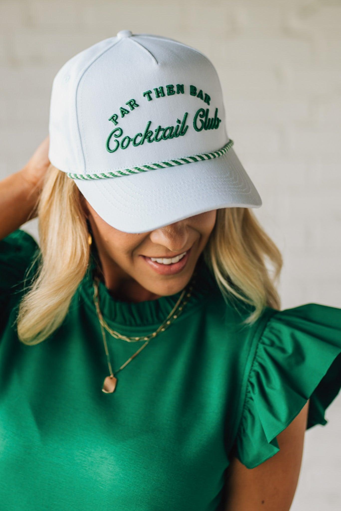 Blonde woman wearing a white hat with green embroidery and twist rope across the brim, front panel says "Par then Bar Cocktail Club"