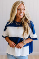 Woman wearing a blue and white striped shirt with a neutral background