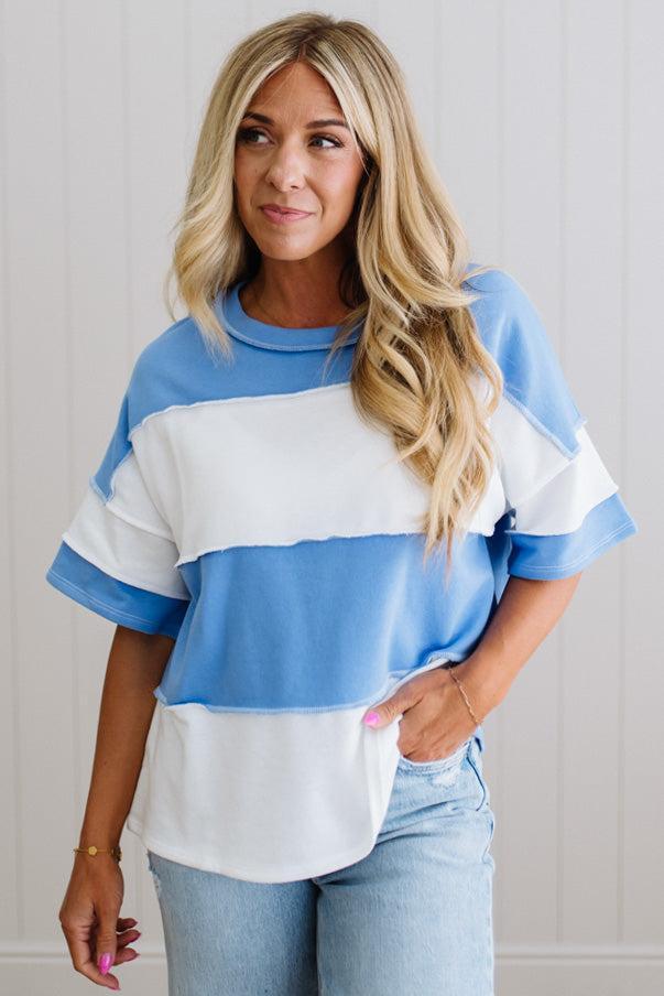 Woman wearing a blue and white striped shirt with a plain background