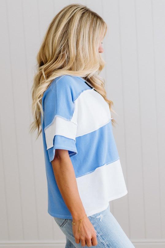 Woman wearing a blue and white striped shirt against a light gray background
